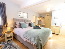 A bedroom with a bed and bedside table at Rainbow's End in Swanton Morley