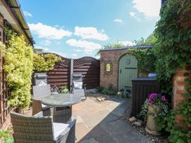 A garden with seating area and a door at Rainbow's End in Swanton Morley