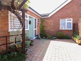 An outdoor area with a door and flowers at Rainbow's End in Swanton Morley