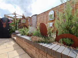 A garden with flower bed and outdoor seating at The Corner House Ufford near Woodbridge