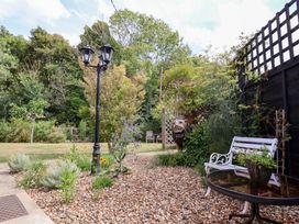 A garden with a lamp post, a table, and a chair at The Corner House in Ufford near Woodbridge