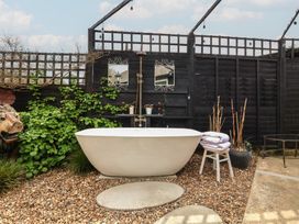A bathtub with towels and plants in a garden at The Corner House Ufford near Woodbridge