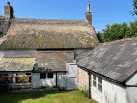 A building with a thatched roof and slate roofs at Vinney Cottage in Owermoigne