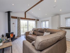 A living room with a sofa and wood stove at Lakeside Lodge near Bowland Lakes Leisure Village near Garstang