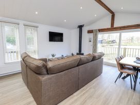 A living room with a sofa and television at Lakeside Lodge near Bowland Lakes Leisure Village