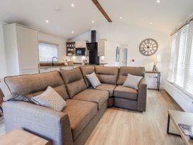 A living room with a sofa and kitchen area at Lakeside Lodge Bowland Lakes Leisure Village near Garstang