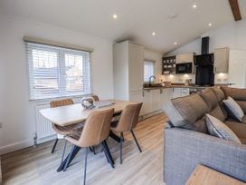 A kitchen and dining area with a table and chairs at Lakeside Lodge Bowland Lakes Leisure Village near Garstang