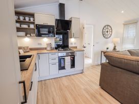 A kitchen with sink stove and microwave at Lakeside Lodge Bowland Lakes Leisure Village near Garstang