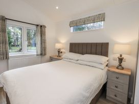 A bedroom with a bed and nightstand at Lakeside Lodge near Bowland Lakes Leisure Village