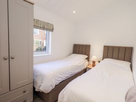 A bedroom with two single beds and a wardrobe at Lakeside Lodge Bowland Lakes Leisure Village near Garstang