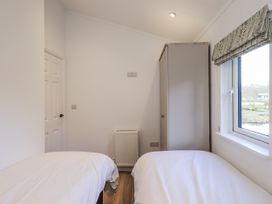 A bedroom with two beds and a wardrobe at Lakeside Lodge near Bowland Lakes Leisure Village