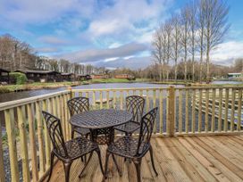 An outdoor seating area by a lake at Lakeside Lodge near Bowland Lakes Leisure Village