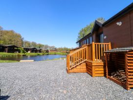An outdoor area with wooden stairs and a lake at Lakeside Lodge in Bowland Lakes Leisure Village near Garstang