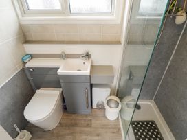 A bathroom with a toilet sink vanity and shower cubicle at 104 The Laurels in Chapel St Leonards