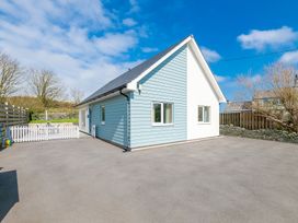 A house with a driveway and a fence at Moranedd Bach in Holyhead
