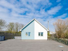 A house with a driveway and trees at Moranedd Bach in Holyhead