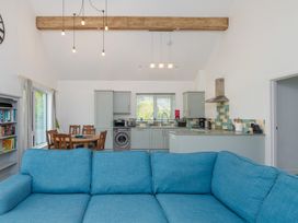 A living room with a sofa and kitchen in Moranedd Bach in Holyhead