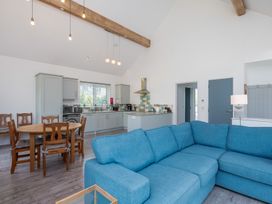 A living room with a sofa and dining table at Moranedd Bach in Holyhead