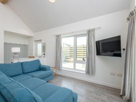 A living room with a sofa and television at Moranedd Bach in Holyhead