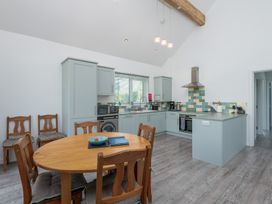 A kitchen with a table and chairs at Moranedd Bach in Holyhead