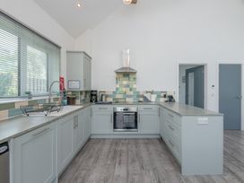 A kitchen with cabinets, a cooker, and a sink at Moranedd Bach in Holyhead