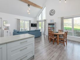 A living room with sofa and dining table at Moranedd Bach in Holyhead