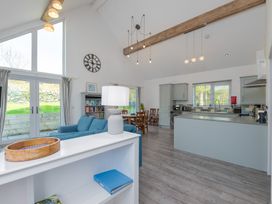 A living room with a kitchen area and seating at Moranedd Bach in Holyhead