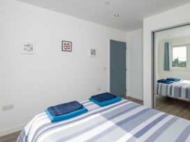 A bedroom with a bed and towels at Moranedd Bach in Holyhead