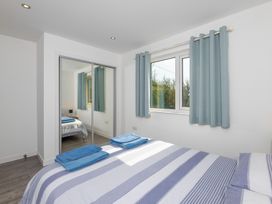 A bedroom with a bed and blue towels at Moranedd Bach in Holyhead