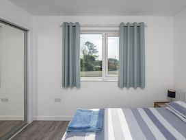 A bedroom with a bed and towel at Moranedd Bach in Holyhead