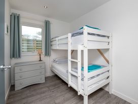 A bedroom with a bunk bed and dresser at Moranedd Bach in Holyhead