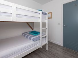 A bedroom with a bunk bed and towels at Moranedd Bach in Holyhead
