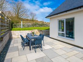 An outdoor patio with a table and chairs at Moranedd Bach Holyhead