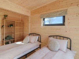 A bedroom with two single beds and a wooden shelving unit at Foxglove Higher Wambrook near Chard
