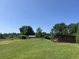 A wooden cabin and picnic table on grass at Foxglove in Higher Wambrook near Chard