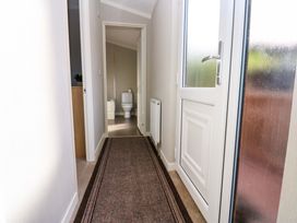 A hallway with a carpet runner leading to a bathroom with a toilet visible at Dragonfly in Tunstall near Hipswell