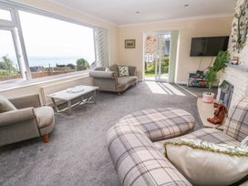 A living room with large windows and a sofa at Karenza in Penzance