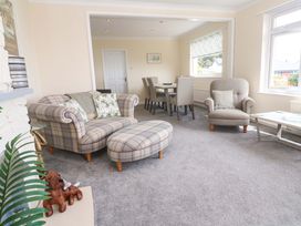 A living room with a sofa and dining area at Karenza in Penzance