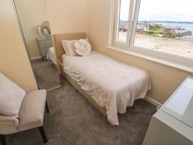 A bedroom with a bed and a dresser at Karenza in Penzance