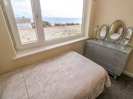 A bedroom with a bed and dresser at Karenza in Penzance