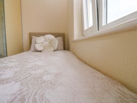 A bed with a pillow near a window at Karenza in Penzance