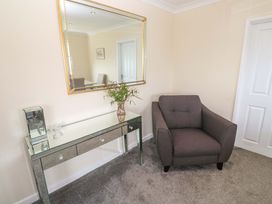 A living room with a chair and console table at Karenza, Penzance