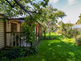 A garden with a house and trees at The Cabin at Little Timbers Ringwood
