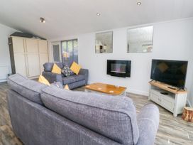 A living room with a sofa and television at Dovedale Lodge Troutbeck Bridge