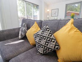 A living room with a sofa and cushions at Dovedale Lodge Troutbeck Bridge