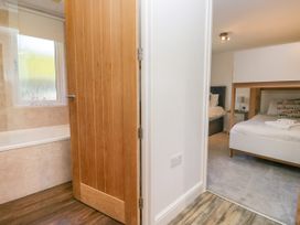 A bedroom with a bed and door at Dovedale Lodge Troutbeck Bridge