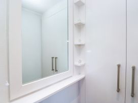A mirror and cabinet in a bathroom at Dovedale Lodge Troutbeck Bridge