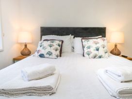 A bedroom with a bed and bedside lamp at Dovedale Lodge Troutbeck Bridge
