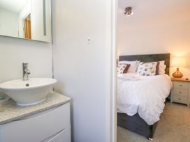A bedroom with a bed and sink at Dovedale Lodge in Troutbeck Bridge