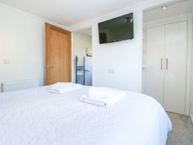 A bedroom with a bed and television at Dovedale Lodge in Troutbeck Bridge